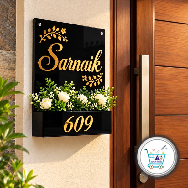 Modern Black Acrylic Planter Name Plate Entrance Wall Installation black A4 size Acrylic Planter Name Plates by artsNprints shipping across India product installation photo Wall-mounted black A4 acrylic planter nameplate with gold font "Sarnaik" and house number 609 installed next to a modern wooden front door.